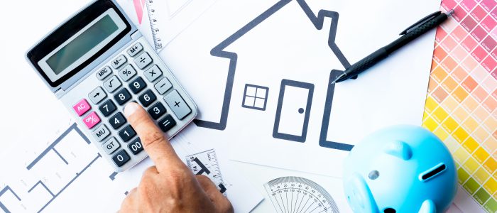 buying a house , economy concept with band using calculator and money box