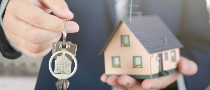 Real estate agent with home keys and house miniature. realestate key apartment real estate home house homeowner concept